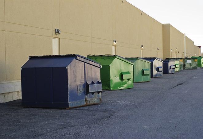 a row of heavy-duty dumpsters ready for use at a construction project in Brooks